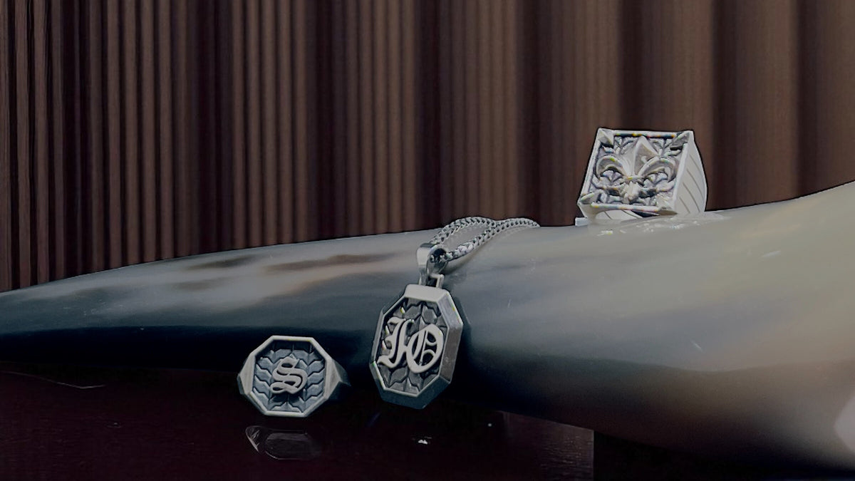 Silver jewelry set on a dark surface with a brown curtain background